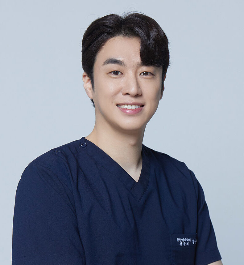 Portrait of Dr. JuYoung Jeong wearing a navy blue medical uniform, smiling confidently, renowned expert in aesthetic prosthetics. • KOREA NEW N DENTAL CLINIC