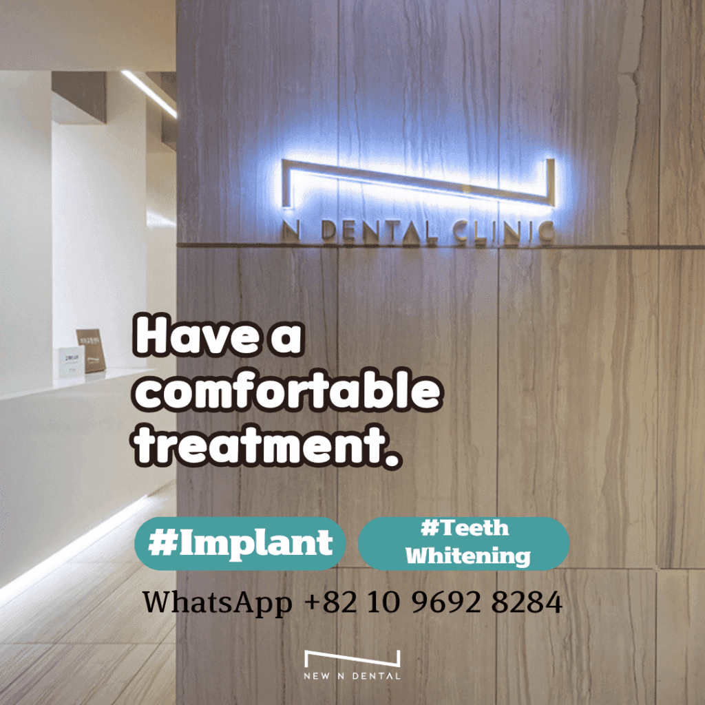 Interior view of a modern dental clinic with the text 'Have a comfortable treatment.' Highlighted hashtags include #Implant and #Teeth Whitening, along with a WhatsApp contact number: +82 10 9692 8284.